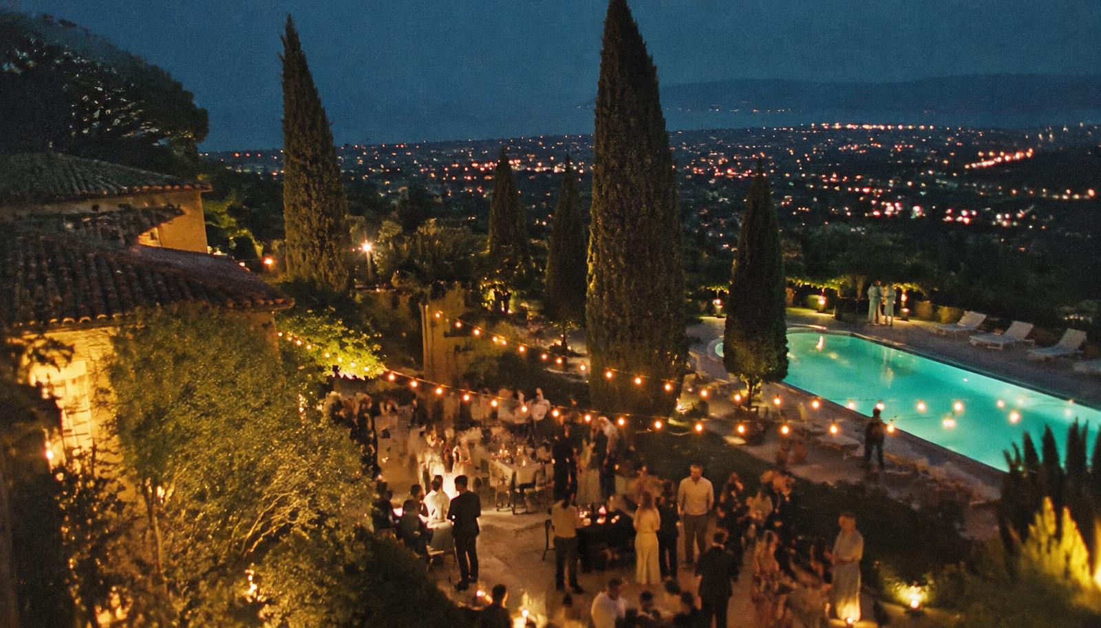 A villa garden party with string lights and a glowing pool